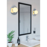 Castrovido bathroom wall lights in chrome with pebble-shaped backplates and opal glass globe shades, mounted either side of a black-framed mirror above a washbasin.