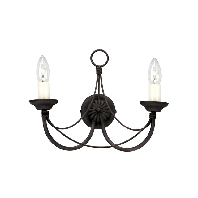 The Carisbrooke 2 Light Wall Light - Black embodies vintage elegance with its Gothic-inspired design. It showcases two candle-shaped bulbs, gracefully curved metal arms, a circular base, and an ornamental loop at the top, all contrasted against a pristine white background.