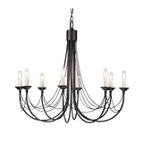 The Carisbrooke 8 Light Chandelier - Black features eight candle-shaped bulbs arranged in a circle, exuding vintage charm. Its elegant metal arms with Gothic-inspired curves are suspended by a robust chain, casting a soft and warm glow that enhances any room.