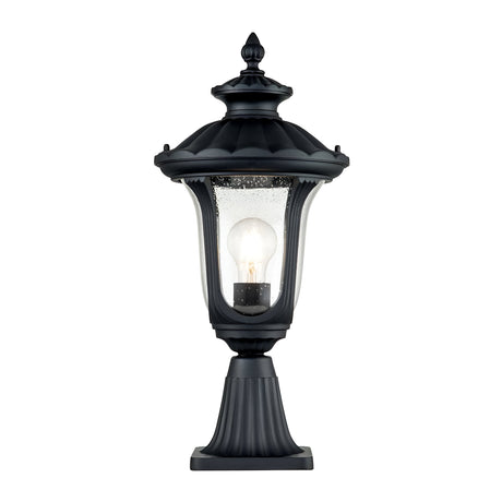 The Chicago Small Pedestal Lantern - Black is designed with a vintage touch, showcasing a clear glass enclosure and a visible light bulb inside. Featuring a decorative top and a fluted base, this black outdoor lantern is perfect for garden lighting or adding charm to your front door.