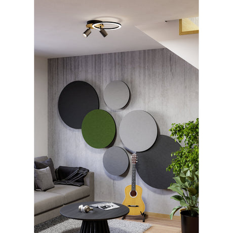 Cembrano LED flush ceiling light in black and natural wood, with a round glowing ring and two adjustable spotlights, mounted above a living room wall display with circular acoustic panels.