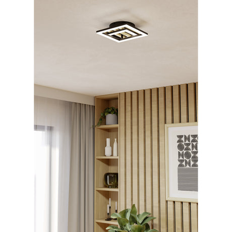 Cembrano LED flush ceiling light in black and natural wood, square layered frame design mounted on a plain ceiling in a hallway setting with wooden wall panelling and shelving below.