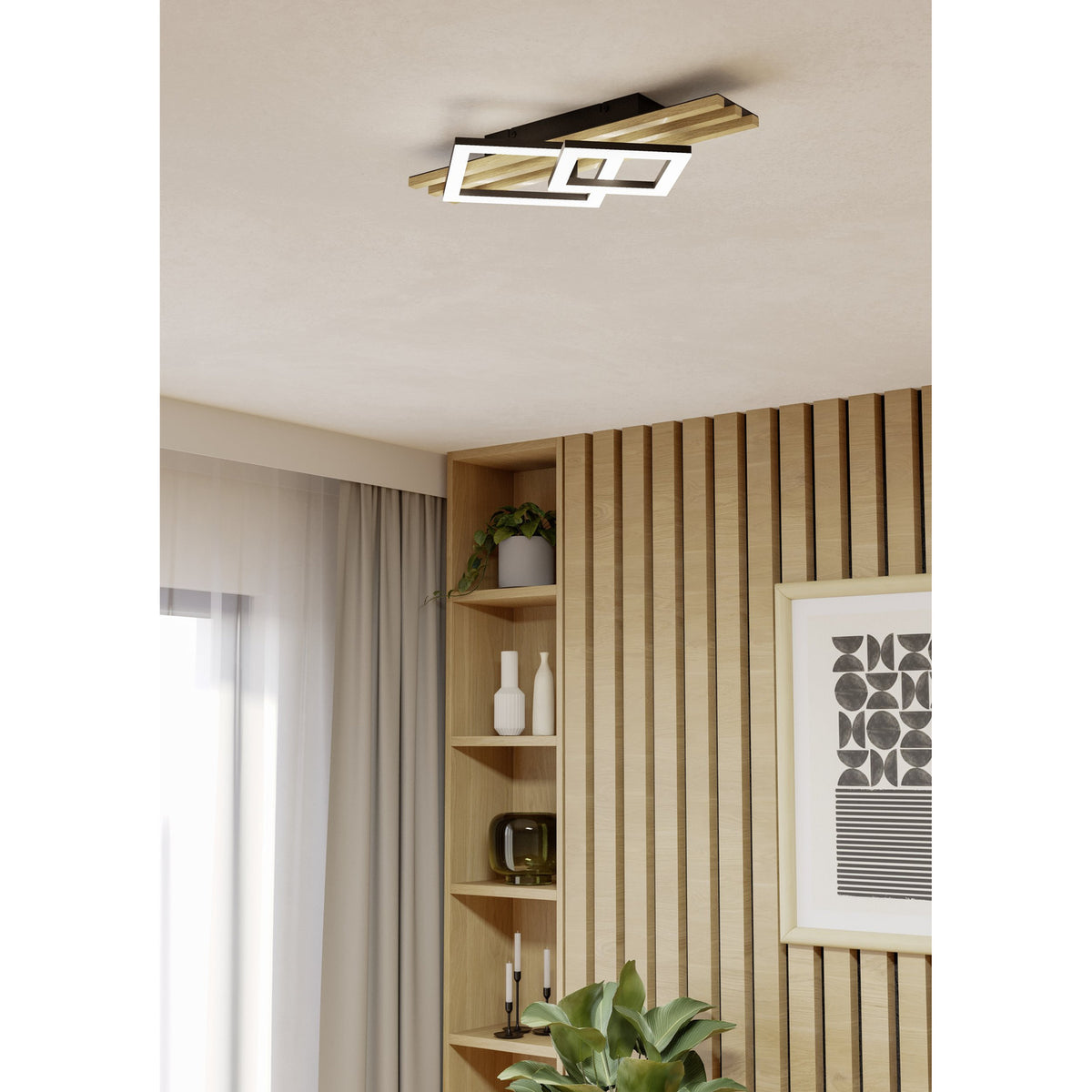 Cembrano LED flush ceiling light in black and natural wood, mounted on a living room ceiling above a wood-slatted wall with shelving and decor.