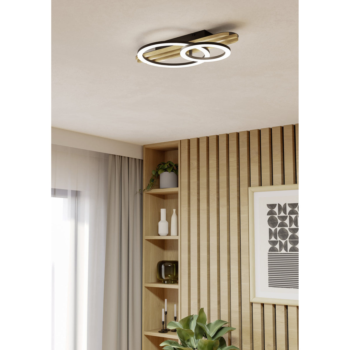 Cembrano 50cm LED flush ceiling light in black and natural wood, with two overlapping rings of varying size and white diffuser faces, mounted in a wood-panelled living room.