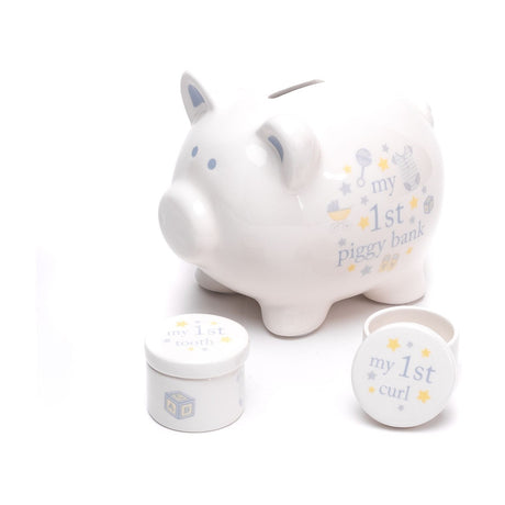 White ceramic piggy money box with blue ear and eye accents, "my 1st piggy bank" text with stars, beside round "my 1st tooth" and "my 1st curl" keepsake pots.