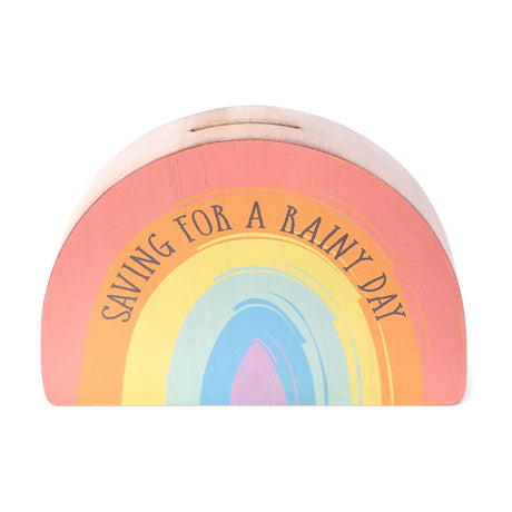 Arched MDF money box shaped like a rainbow, printed with "Saving for a Rainy Day" over pink, orange, yellow, mint, blue and lilac bands, natural wood edges, coin slot on top, plain white background.