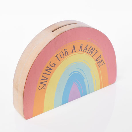 Half-circle MDF money box with a coin slot, printed with a multicoloured rainbow and "Saving for a Rainy Day" text, natural wood edges, on a plain white background.