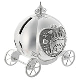 Silverplated metal money box shaped like a pumpkin coach, with a smooth rounded body, scrolled finial, spoked wheels, and a princess panel with hearts and flowers, shown on a white background.