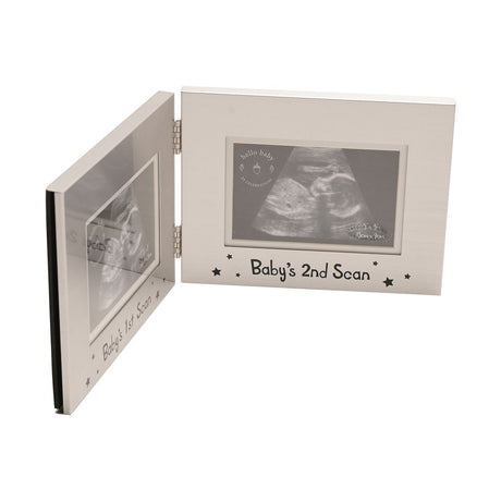 Hinged double aluminium photo frame in silver, opened at an angle, with "Baby's 1st Scan" and "Baby's 2nd Scan" windows in black star-dotted lettering, shown on a white background.