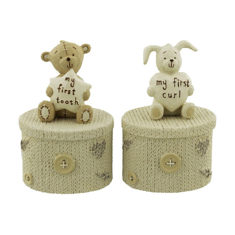 Round cream resin keepsake box set with knitted-look texture and button details, topped with a teddy bear holding a "my first tooth" star and a rabbit holding a "my first curl" heart.