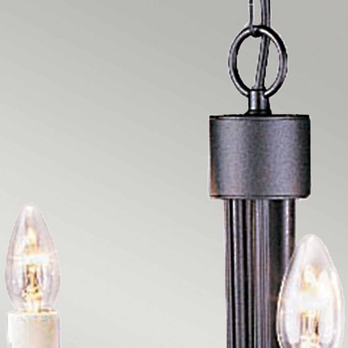 Close-up of the Chartwell 5 Light Chandelier - Black, featuring two candle-shaped exposed light bulbs. This sophisticated lighting piece includes a metal rod and chain, set against a plain, light gray background that embodies classic elegance.