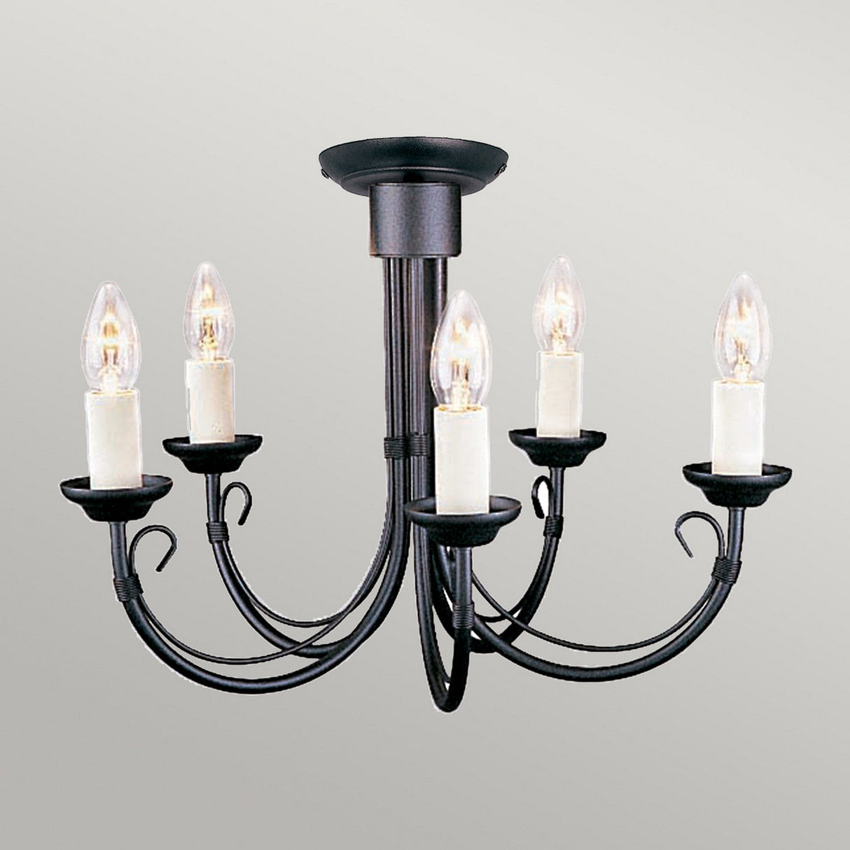 Introducing the Chartwell 5 Light Chandelier in Black, an epitome of classic elegance. This exquisite piece features five upward-facing candle-style bulbs, each elegantly set in a cream holder. The chandelier's design includes gracefully curved arms extending from a central stem on a circular base, offering timeless lighting solutions against a simple light gray backdrop.