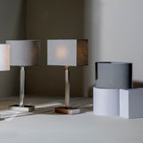 Chartstead Rectangular 27cm Tapered Lamp Shade in grey fabric, shown fitted to a table lamp alongside matching shades in a room setting.