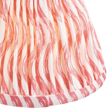 Close-up of Endon Chartwood 16cm tapered lamp shade in coral pink, showing pleated faux linen with rippled print and taped edge trim.