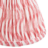 Close-up of Endon Chartwood 16cm tapered lamp shade in coral pink, showing pleated faux linen with a rippled print and taped edge trim.