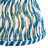 Close-up of the Endon Chartwood 16cm tapered lamp shade in marlin blue, showing pleated faux linen with a rippled blue and cream print and taped edge.