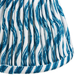 Close-up of Endon Chartwood 16cm tapered lamp shade in marlin blue, showing pleated faux linen with a rippled blue and white print and taped edge.