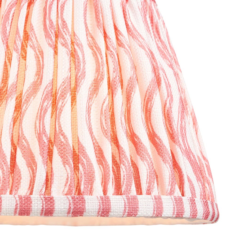 Close-up of Endon Chartwood 20cm tapered lamp shade in coral pink and white, showing pleated faux linen with a rippled wave print and taped edge trim.