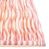 Close-up of Endon Chartwood 20cm tapered lamp shade in coral pink and white, showing pleated faux linen with a rippled wave print and taped edge trim.