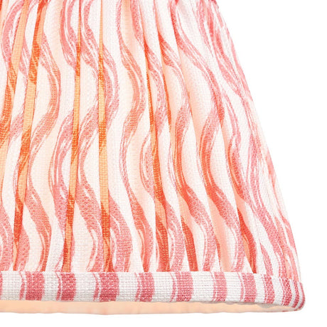 Close-up of Endon Chartwood 20cm tapered lamp shade in coral pink and white, showing pleated faux linen with a rippled wave print and taped edge trim.
