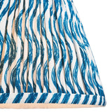 Close-up of Endon Chartwood 20cm tapered lamp shade in marlin blue and white, showing pleated faux linen with a rippled print and taped edge trim.