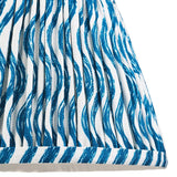Close-up of the Endon Chartwood 20cm tapered lamp shade in marlin blue, showing pleated faux linen with a rippled blue and white print and taped edge.
