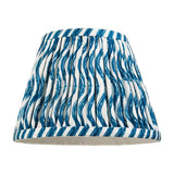 Endon Chartwood 20cm tapered lamp shade in marlin blue and white pleated faux linen with a rippled wave print and taped edge trim, on a white background.