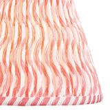 Close-up of the Chartwood 25cm tapered lamp shade in coral pink, showing pleated faux linen fabric with a wavy pattern and striped taped edge trim.