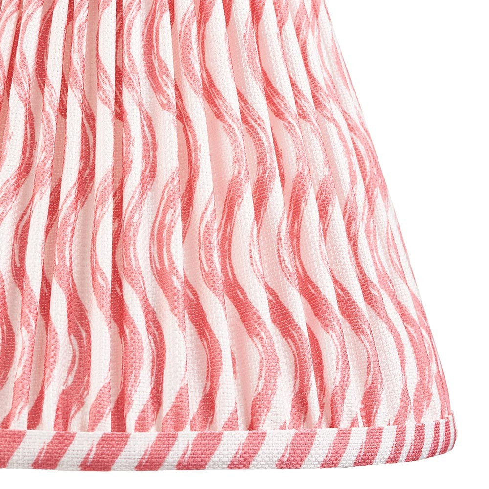 Close-up of the Chartwood 25cm tapered lamp shade in coral pink, showing pleated faux linen fabric with a ripple pattern and taped edge trim.