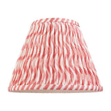 Chartwood 25cm tapered lamp shade in coral pink, pleated faux linen with striped pattern and taped edges, shown on a plain white background.