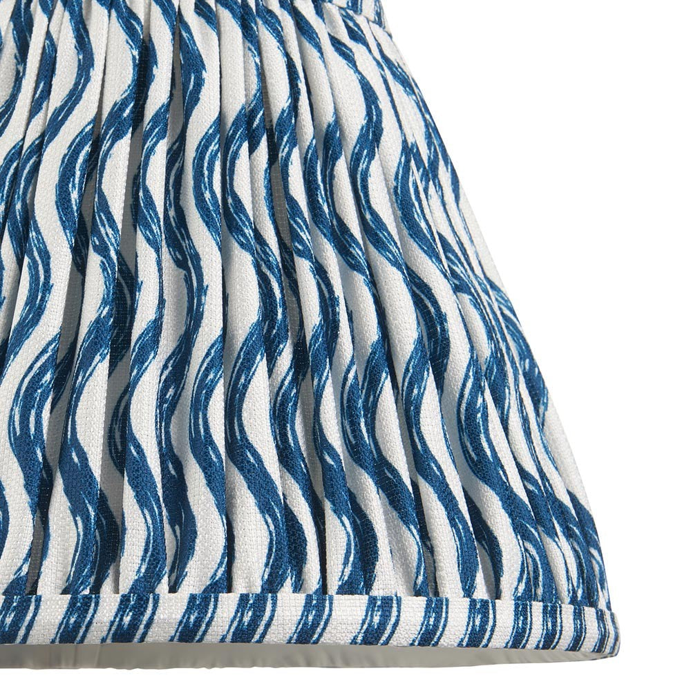 Close-up of Endon Chartwood 25cm tapered lamp shade in marlin blue, showing pleated faux linen with a rippled wave print and taped edge detail.