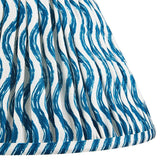 Close-up of Endon Chartwood 30cm tapered lamp shade in marlin blue, showing pleated faux linen with a blue ripple print and taped edge trim.
