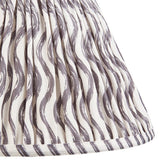 Close-up of Endon Chartwood 30cm tapered lamp shade in pearl grey, showing pleated faux linen with a rippled grey wave print and taped hem.