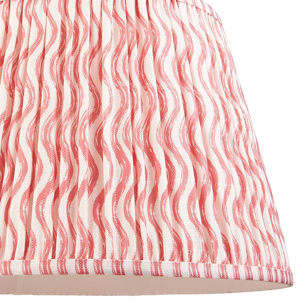 Close-up of Endon Chartwood 40cm tapered lamp shade in coral pink and white, showing pleated faux linen with a rippled wave print and taped edge trim.