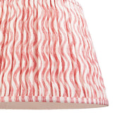 Close-up of Endon Chartwood 40cm tapered lamp shade in coral pink and white, showing pleated faux linen with a rippled wave print and taped edge trim.