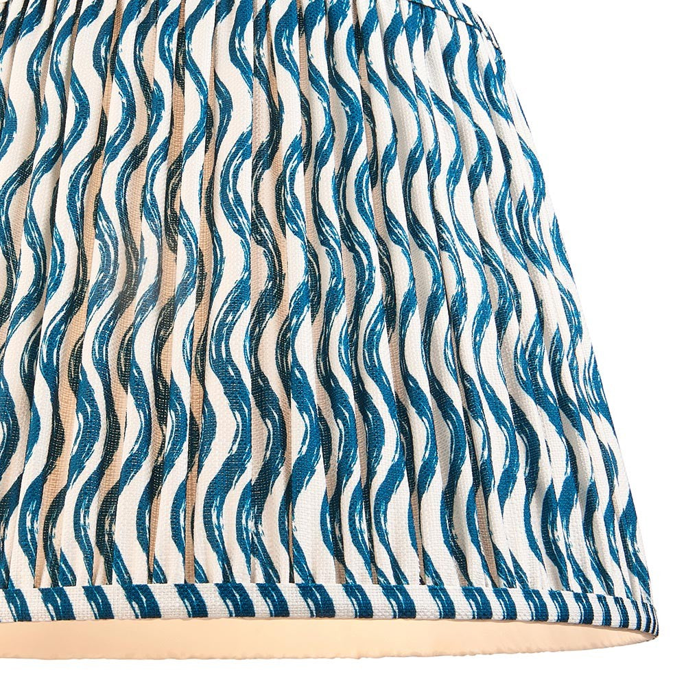 Close-up of the Endon Chartwood 40cm tapered lamp shade in marlin blue, showing pleated faux linen with a wavy ripple print and taped edge.
