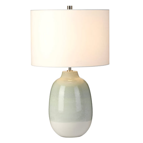 The Chelsfield Table Lamp - Pale Green & White showcases a minimalist design with its light green and white ceramic base, topped by a large white cylindrical shade. This contemporary piece stands gracefully on a white backdrop, seamlessly combining simplicity and elegance.