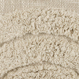Close-up of the Chevery cushion in natural cream cotton, showing a tufted arc pattern against a loosely woven, slubby flat-weave fabric.