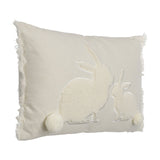 Chevery rectangular cushion in natural and white woven cotton with two sherpa fleece rabbit appliqués, pompom tails, and fringed edges, shown on a plain white background.