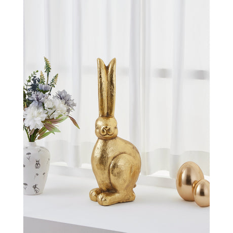 Chilandy Stone Rabbit Ornament in gold finish, seated with tall upright ears, displayed on a windowsill beside a floral vase and gold decorative eggs.
