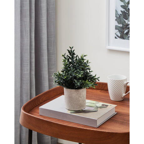 Chitose Artificial Plant 23cm in a pale grey mottled pot, shown on a wooden side table beside a book and white mug in a living room setting.