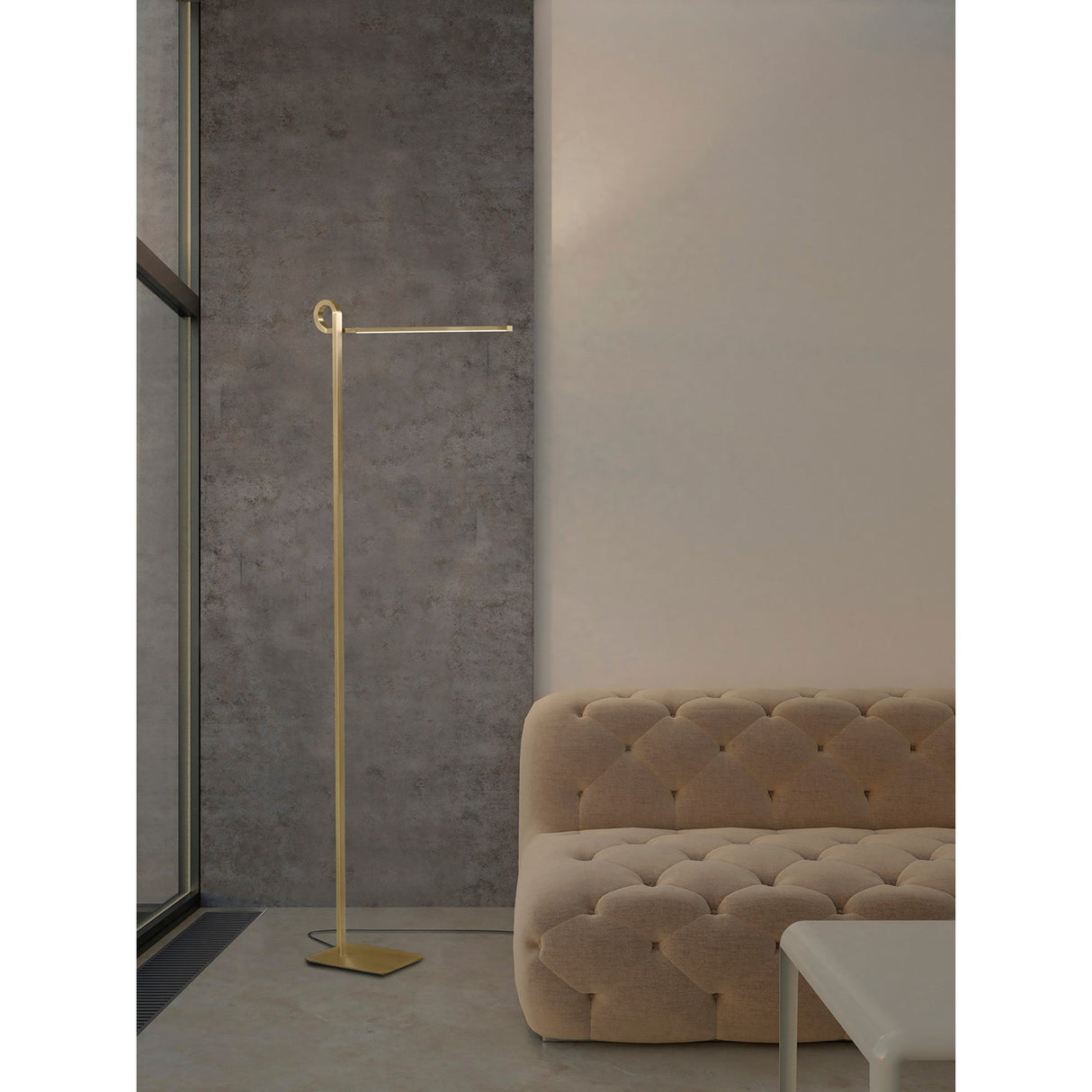 Minimalist living room with a beige tufted sofa, white coffee table, large window by a gray textured wall, and the Cinto Dimmable LED Floor Lamp 20W 3000K in antique brass—ideal for contemporary interiors.