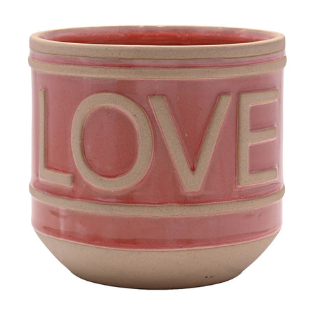 Pink gloss ceramic planter with raised sandy beige "LOVE" lettering, ribbed rim bands and a rounded tapered base, shown on a plain white background.
