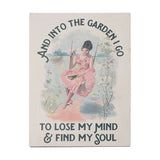 Cream metal wall plaque, 40cm, with arched dark slate text reading "And into the garden I go to lose my mind & find my soul" around an illustration of a woman in a pink dress on a swing.