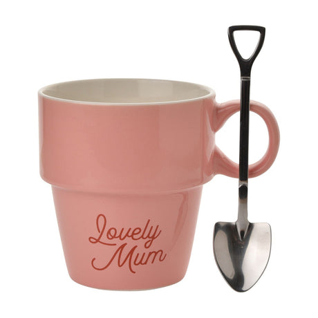 Pink glazed ceramic mug shaped like a flower pot, with "Lovely Mum" script, cream interior, and a trowel resting against the loop handle on a white background.