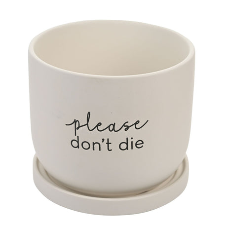 White round ceramic plant pot with matching saucer, matte finish, printed with "please don't die" in black script and lowercase text, on a plain background.