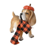 Resin garden ornament of a beagle wearing an orange pumpkin hat, with a tan brown coat, white muzzle and paws, and an orange check fabric scarf, on a plain white background.