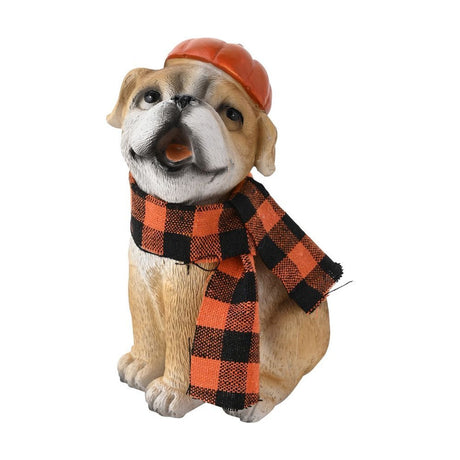 Resin bulldog garden ornament seated with head tilted up, wearing an orange pumpkin-shaped hat and orange-and-black check scarf, tan and white coat, on a plain white background.