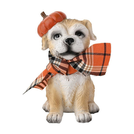 Resin Border Terrier garden ornament sitting upright with an orange pumpkin hat on its head and an orange, black and cream check fabric scarf tied round its neck, on a plain white background.