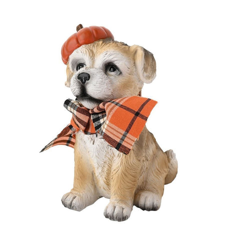 Border Terrier garden ornament in beige resin, sitting with an orange pumpkin hat and orange check fabric scarf tied in a bow, on a plain white background.